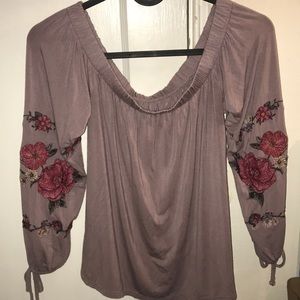 Purple top with flower stitching on the arms